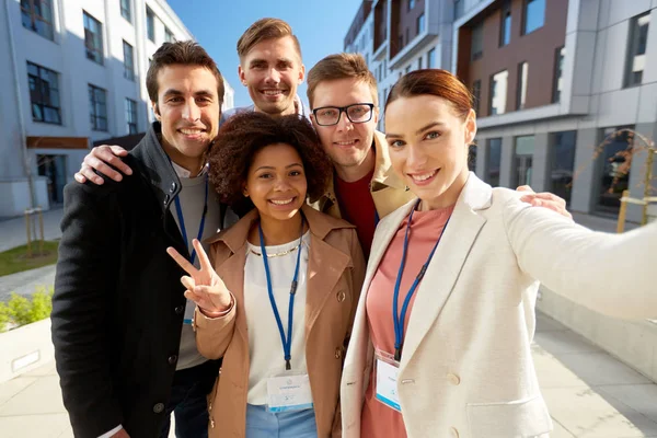 Tým s konference odznaky pořizování selfie v městě — Stock fotografie