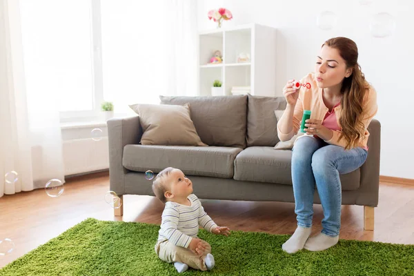 Anne evde bebekle oynarken sabun köpüğü ile — Stok fotoğraf