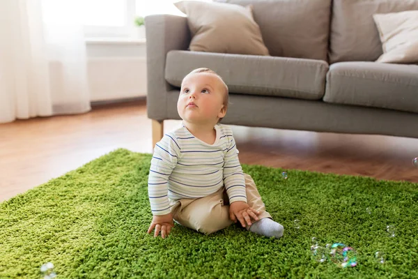 Menino brincando com bolhas de sabão em casa — Fotografia de Stock