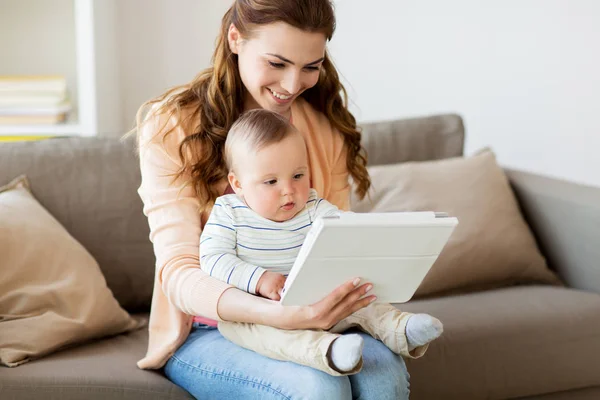 Mãe feliz com bebê e tablet pc em casa — Fotografia de Stock
