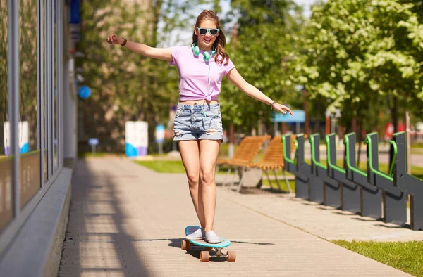 Boldog tizenéves lány lovaglás longboard árnyalatú — Stock Fotó