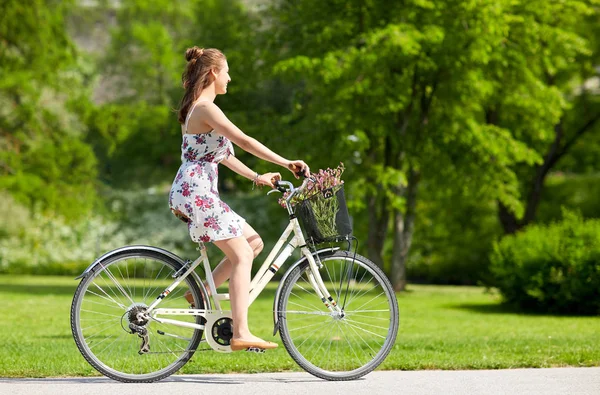 Šťastná žena jedoucí na fixie kole v letním parku — Stock fotografie