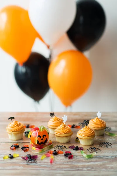 Fiesta de halloween decorado cupcakes en mesa de madera — Foto de Stock