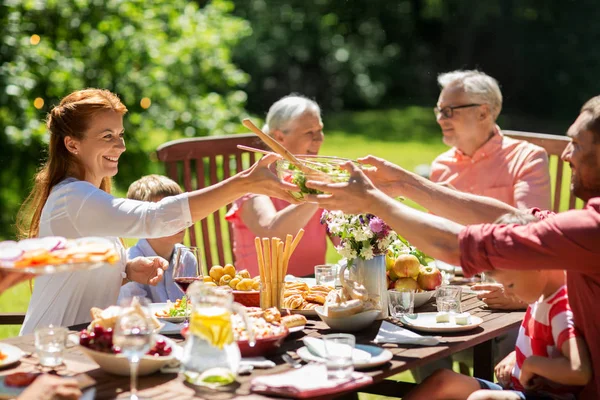 Šťastná rodina s večeří nebo letní zahradní party — Stock fotografie