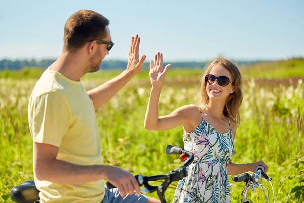 Casal feliz com bicicletas fazendo alta cinco — Fotografia de Stock