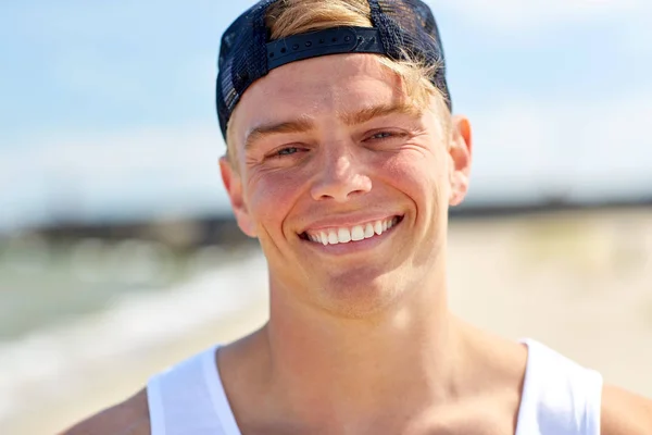 Close up de jovem sorridente na praia de verão — Fotografia de Stock