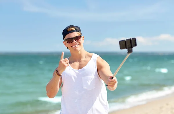 Homme avec smartphone selfie bâton sur la plage d'été — Photo