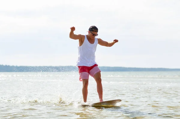 Giovane che cavalca su skimboard sulla spiaggia estiva — Foto Stock