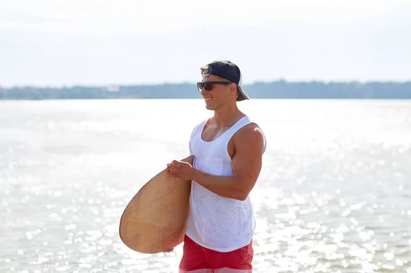 Szczęśliwy młody człowiek z skimboard na lato Plaża — Zdjęcie stockowe