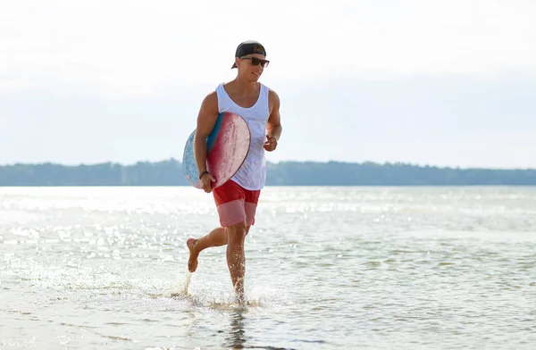 Felice giovane uomo con skimboard sulla spiaggia estiva — Foto Stock