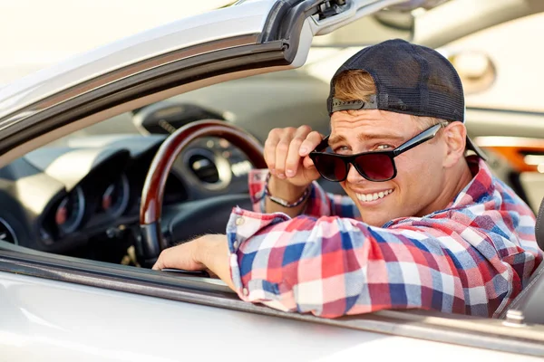 コンバーチブル車を運転の色合いで幸せな若い男 — ストック写真