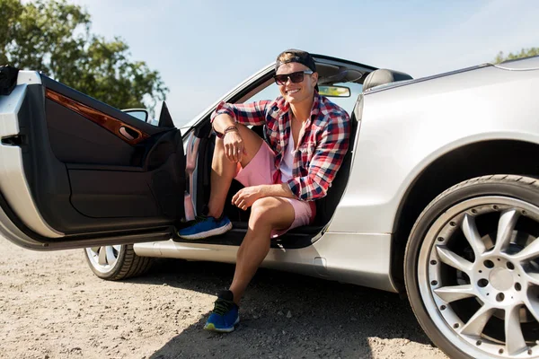 Cabrio araba içinde oturan mutlu genç adam — Stok fotoğraf