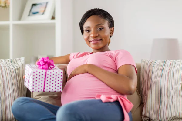 Happy african american pregnant woman with gift — Stock Photo, Image