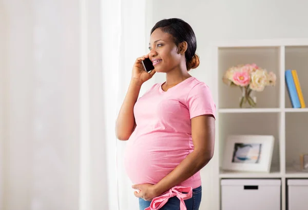 Glückliche Schwangere telefoniert zu Hause mit dem Smartphone — Stockfoto