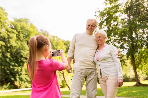 Enkelin fotografiert Großeltern im Park — Stockfoto