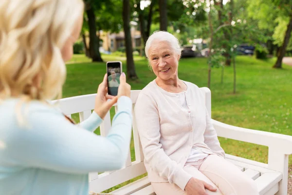 Dochter fotograferen senior moeder door smartphone — Stockfoto