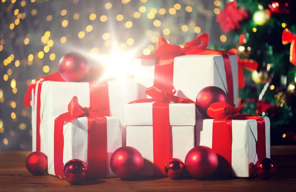 Cajas de regalo y bolas rojas bajo el árbol de Navidad — Foto de Stock