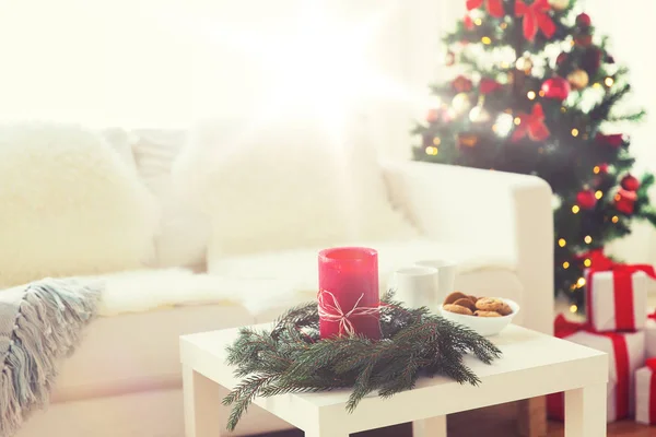 Sofá, mesa e árvore de Natal com presentes em casa — Fotografia de Stock