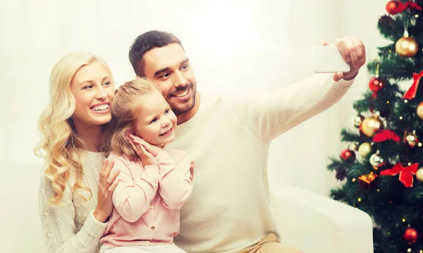 Family taking selfie with smartphone at christmas — Stock Photo, Image