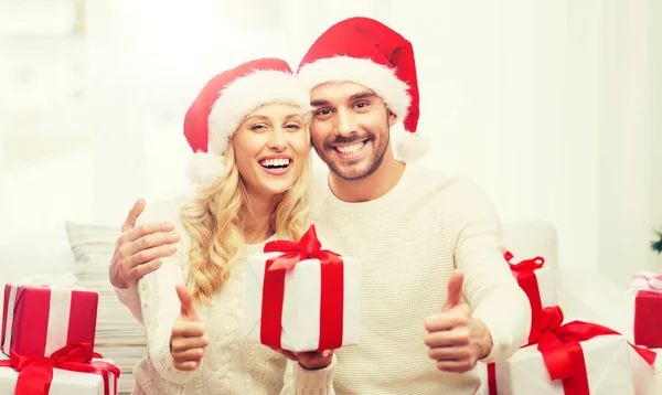 Щаслива пара з різдвяними подарунками і великими пальцями вгору — стокове фото
