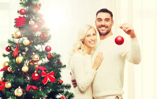 Happy couple decorating christmas tree at home — Stock Photo, Image