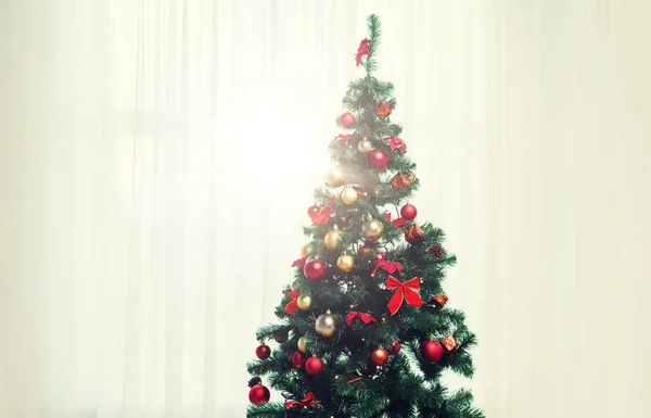 Χριστουγεννιάτικο δέντρο στο σαλόνι πάνω κουρτίνα παραθύρων — Φωτογραφία Αρχείου
