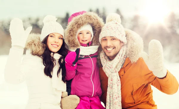 Familia feliz agitando las manos al aire libre en invierno —  Fotos de Stock