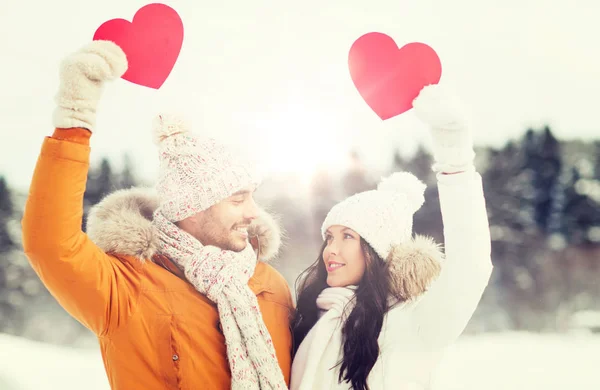 Gelukkige paar met rode harten over winterlandschap — Stockfoto