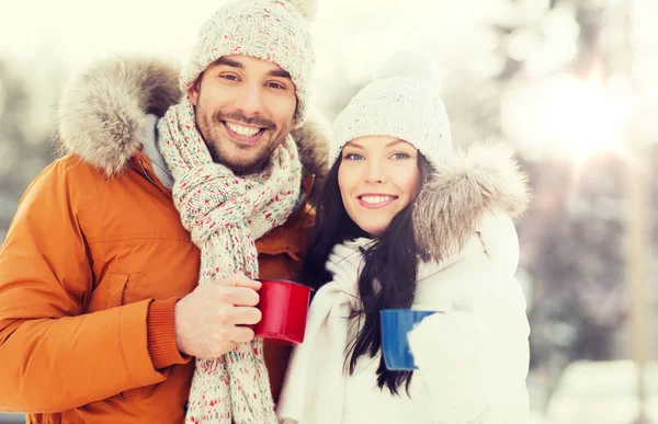 Щаслива пара з чашками чаю над зимовим пейзажем — стокове фото
