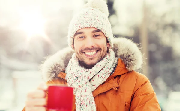 Homem feliz com xícara de chá ao ar livre no inverno — Fotografia de Stock