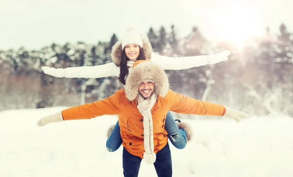 Casal feliz se divertindo sobre fundo de inverno — Fotografia de Stock