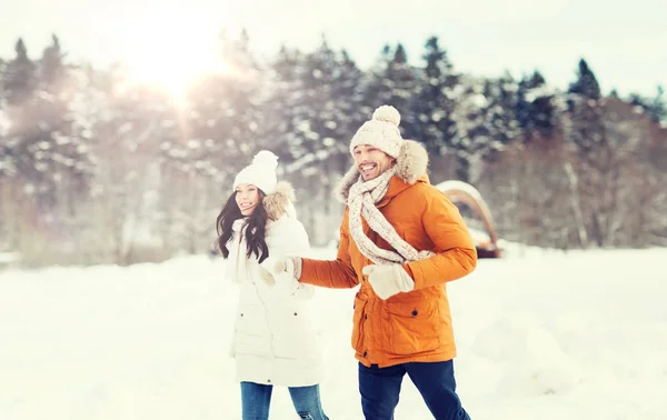 Gelukkige paar loopt over de achtergrond van de winter — Stockfoto