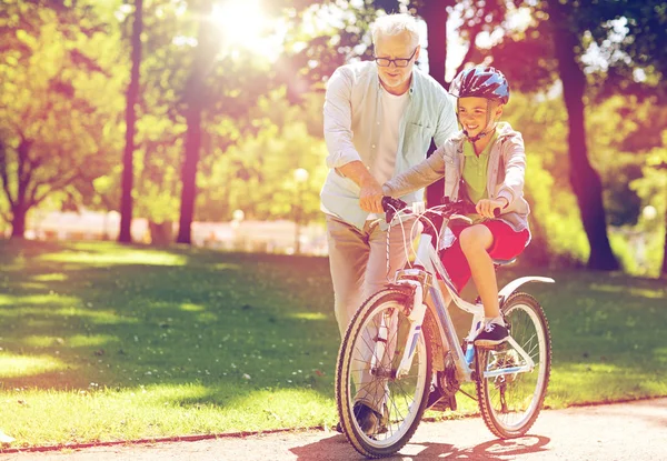Nonno e ragazzo con bicicletta al parco estivo — Foto Stock