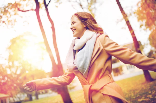 Schöne glückliche junge Frau, die im herbstlichen Park spaziert — Stockfoto