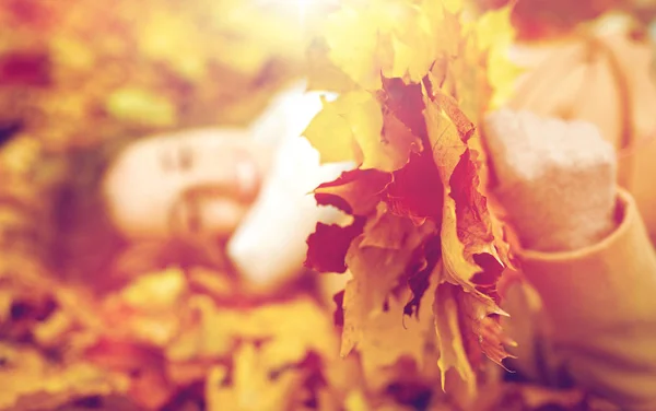 Primo piano di donna felice sdraiata su foglie di autunno — Foto Stock