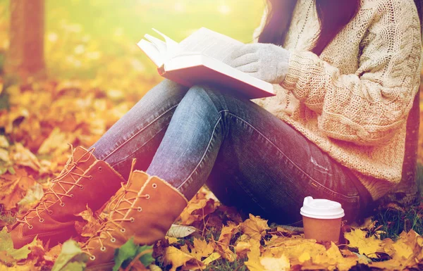 Kobieta z książki picia kawy w jesienny park — Zdjęcie stockowe