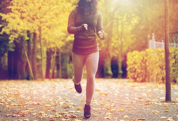 Primer plano de la joven corriendo en el parque de otoño — Foto de Stock