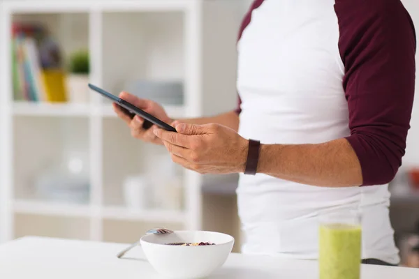 Hombre con tablet pc desayunando en casa — Foto de Stock