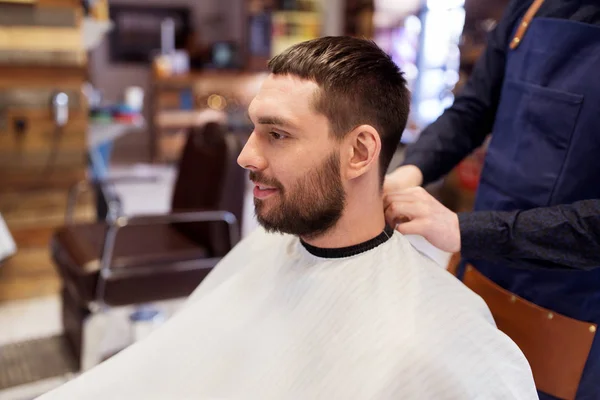 Kapper en man met baard op barbershop — Stockfoto