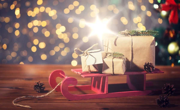 Κοντινό πλάνο Χριστουγέννων κουτιά δώρων σε ξύλινο έλκηθρο — Φωτογραφία Αρχείου