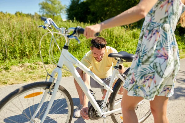 Mutlu genç çift ülke yolda Bisiklet tamir — Stok fotoğraf