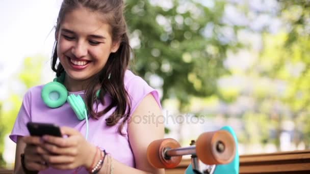 Счастливая девочка-подросток со смартфоном и лонгбордом — стоковое видео