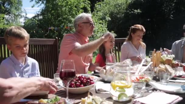 Glad familj som äter middag eller sommarträdgårdsfest — Stockvideo