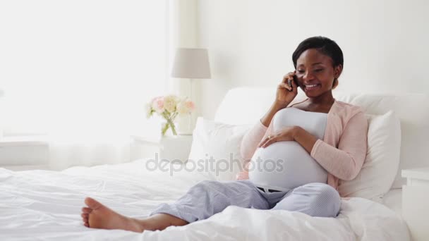Счастливая беременная женщина звонит на смартфон дома — стоковое видео