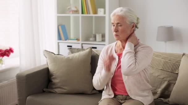 Старшая женщина страдает от боли в шее дома — стоковое видео