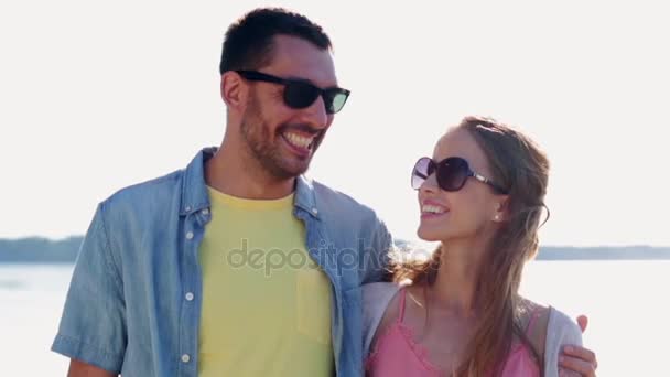 Gelukkige paar in zonnebril knuffelen over zee — Stockvideo