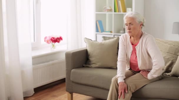 Senior woman suffering from pain in leg at home — Stock Video