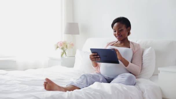 Mutlu hamile kadın yatakta tablet pc ile — Stok video