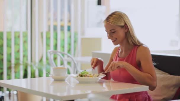 Mujer comiendo y bebiendo café en el restaurante — Vídeos de Stock