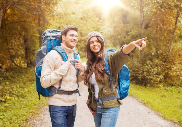 Lachende paar met rugzakken wandelen — Stockfoto